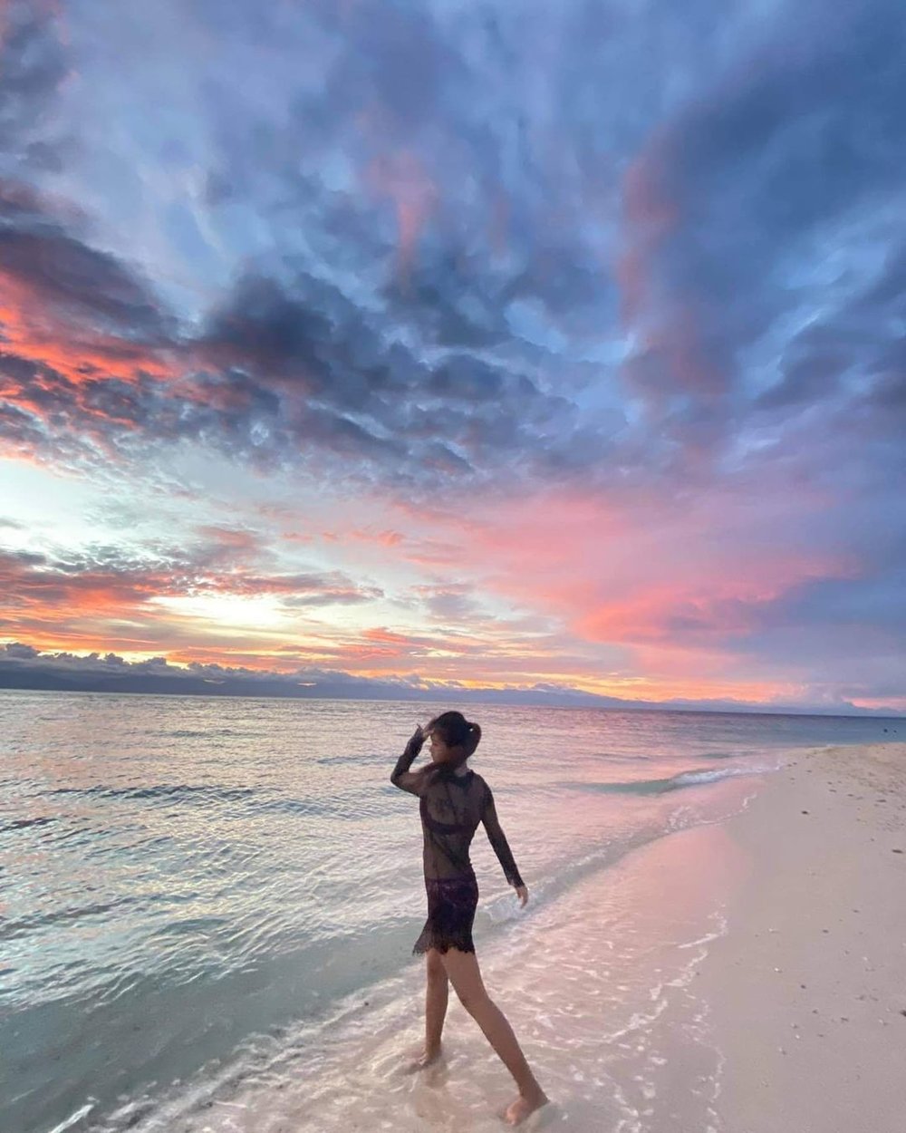 woman posing in beach with pink skies