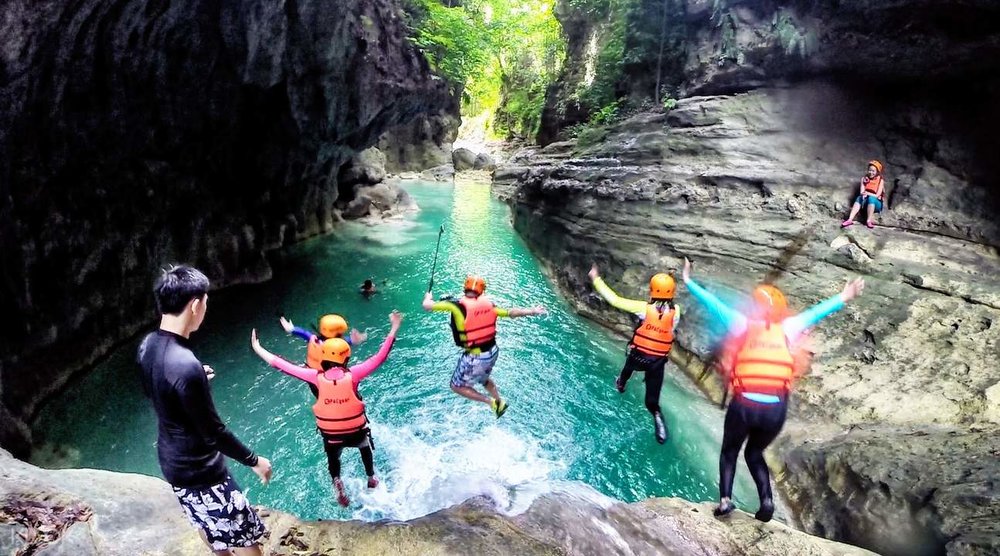 canyoneering group of friends jumping off cliff