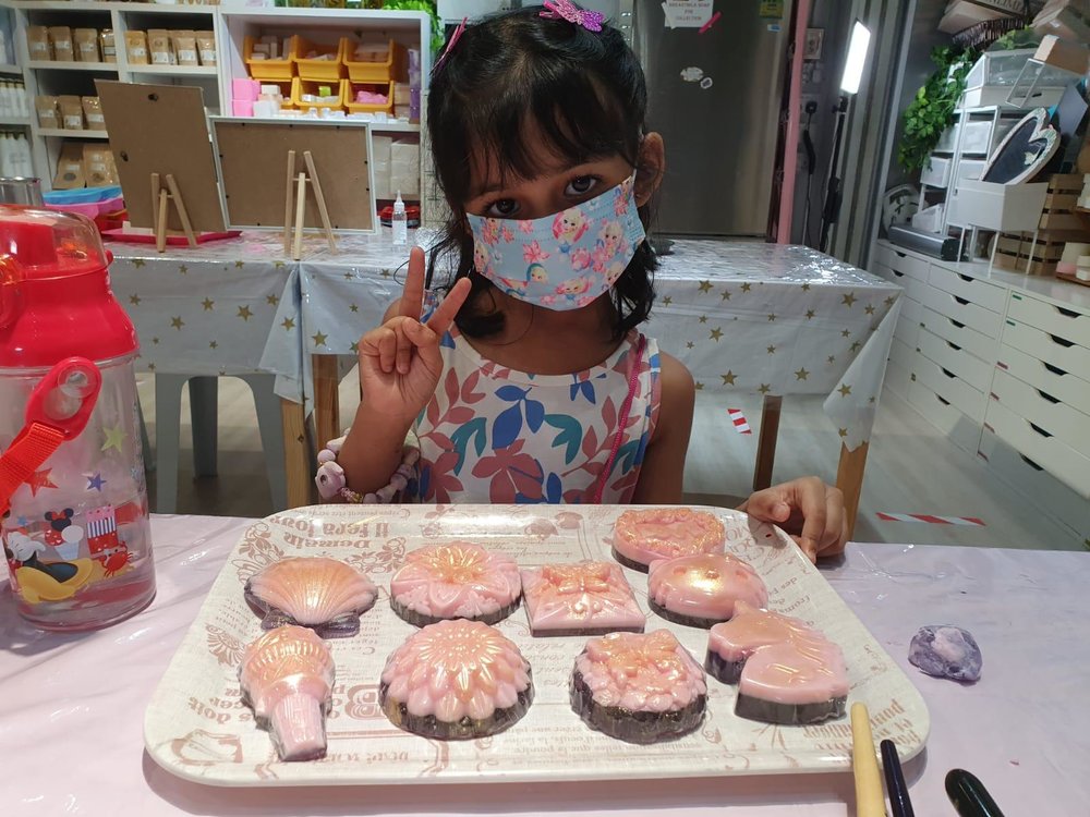 Kid showing her finished soap products