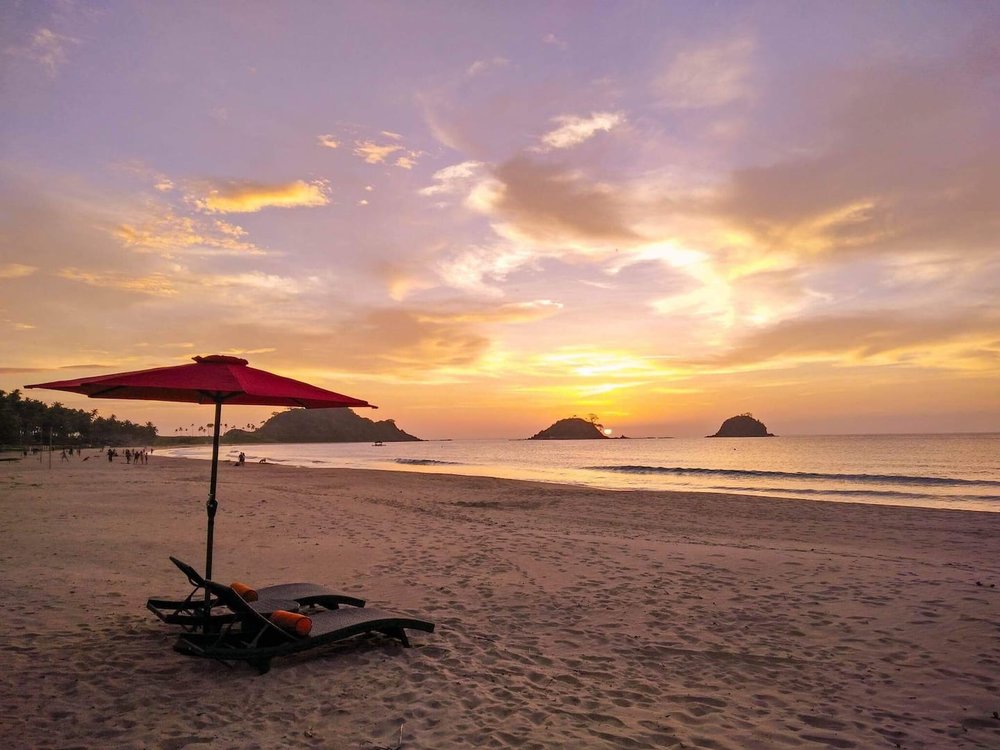 lounging chair under umbrella by beach