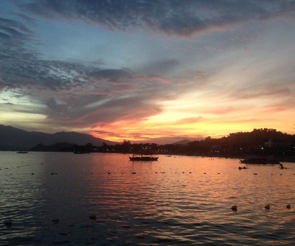 sunset overlooking beach and boats