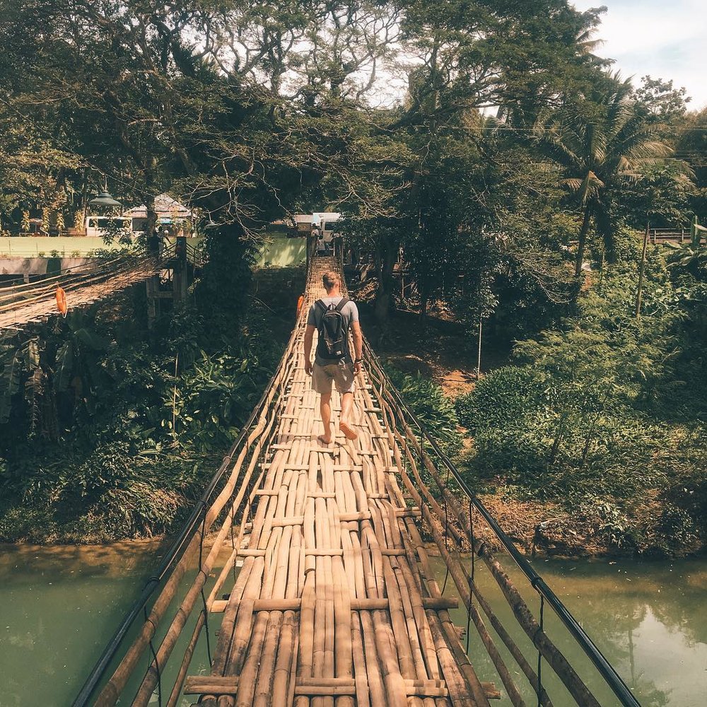 man crossing twin hanging bridge
