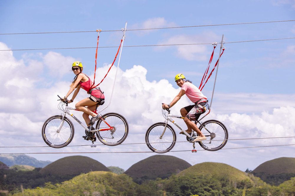 couple smiling while on bikes suspended in the air