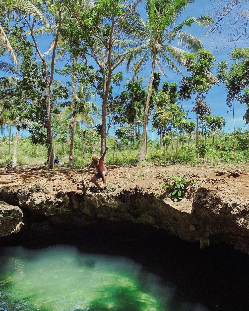man diving in cave pool