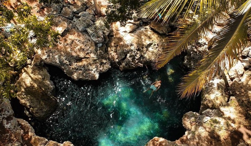 man floating in underground cave pool