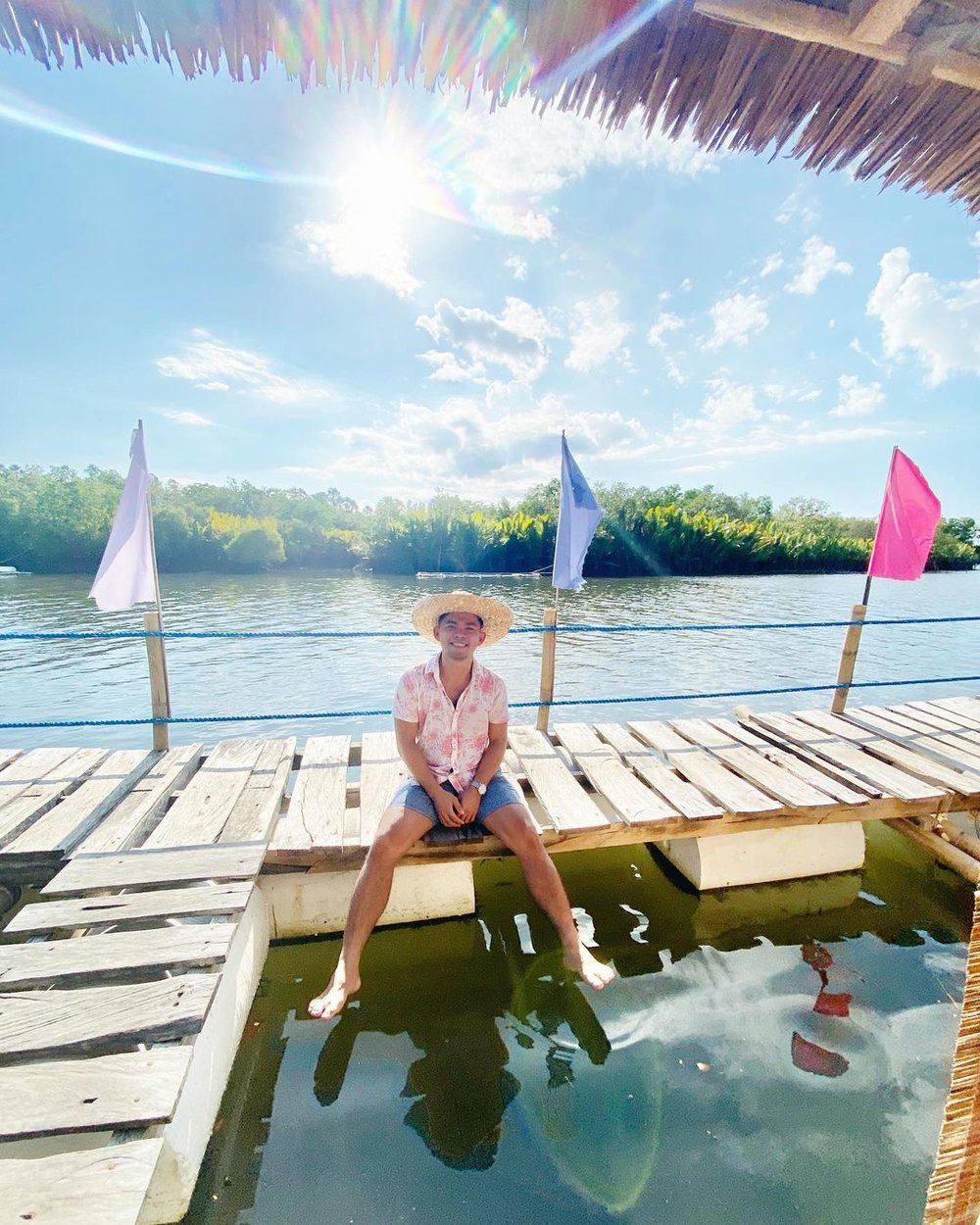 man wearing hat sitting in river walkboard
