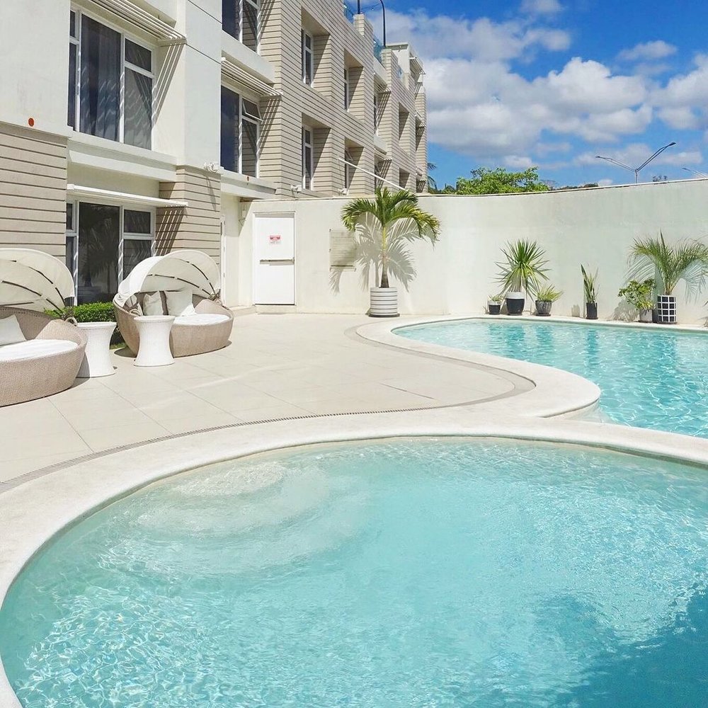 pool surrounding white walled building