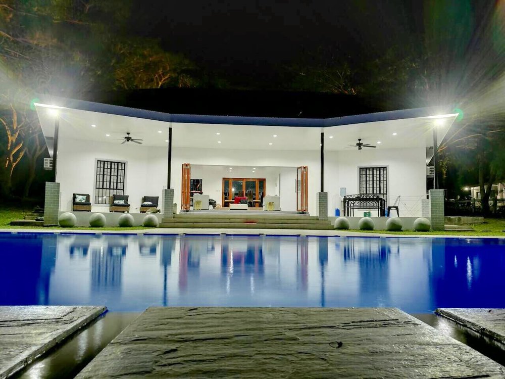 pool in front of white patio and house
