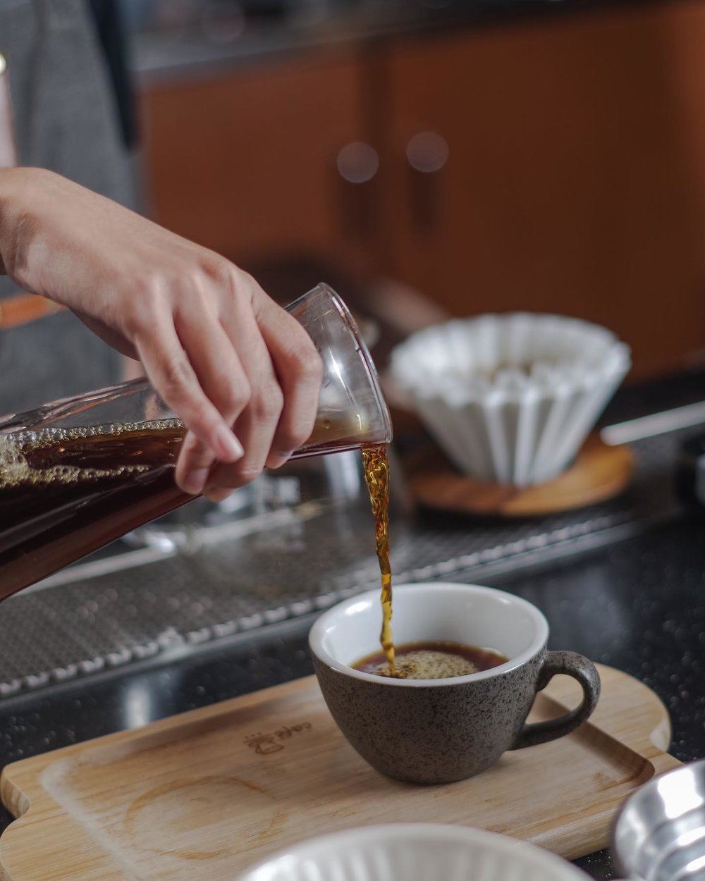 barista pouring coffee into cup