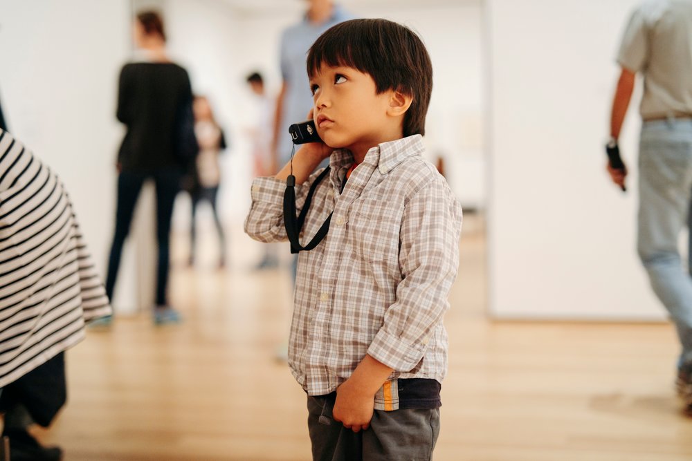 kid listening to an audio guide at museum of modern art new york city