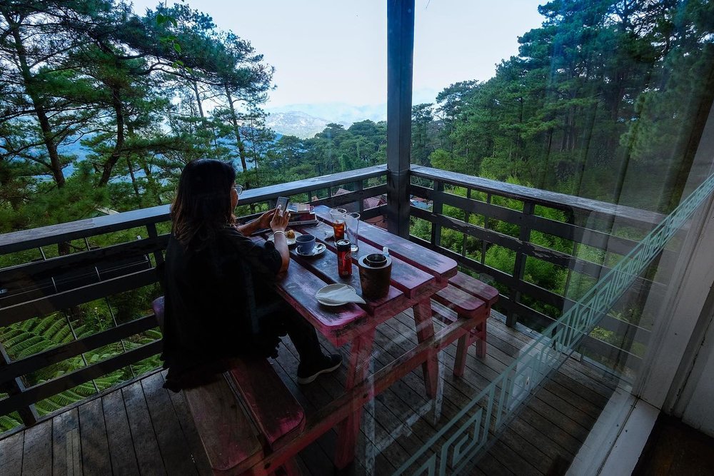 girl eating alone by hillside veranda