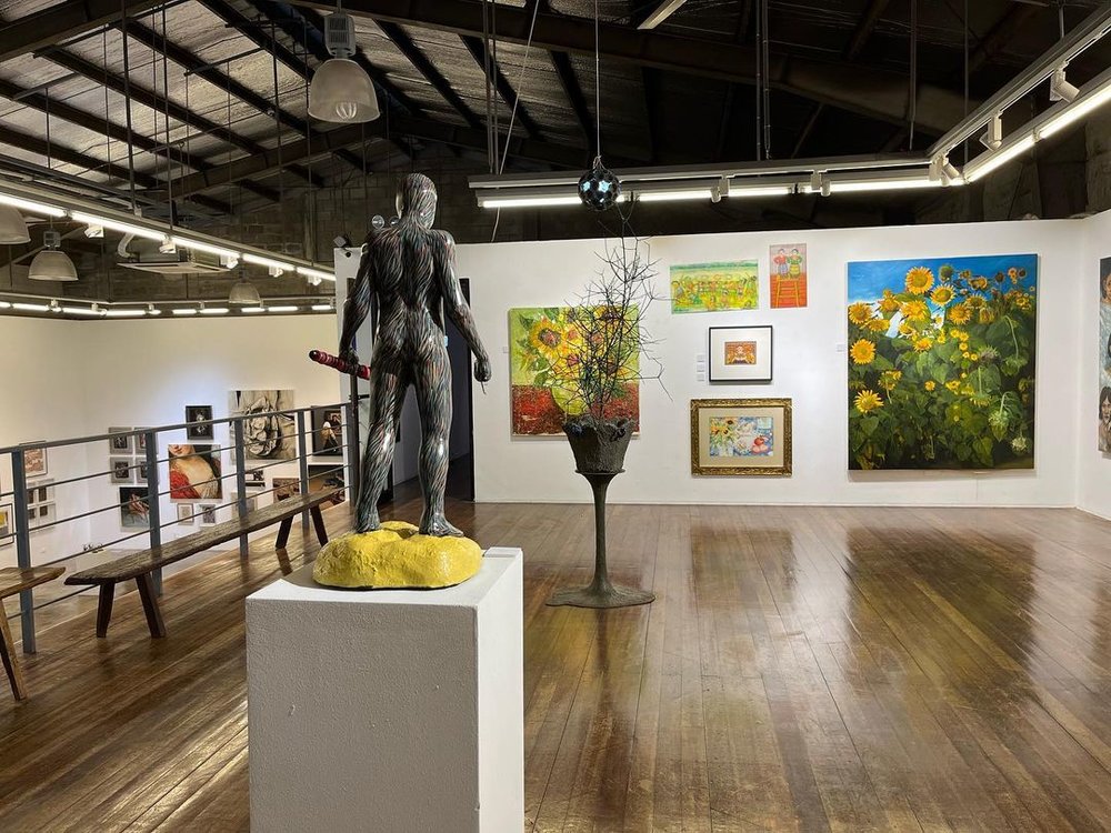 figurine of man surrounded by paintings and art pieces