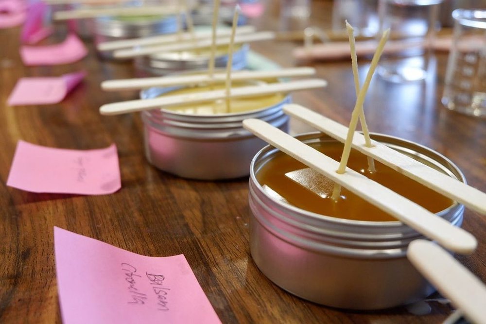tin canisters with candle wax and popsicle sticks