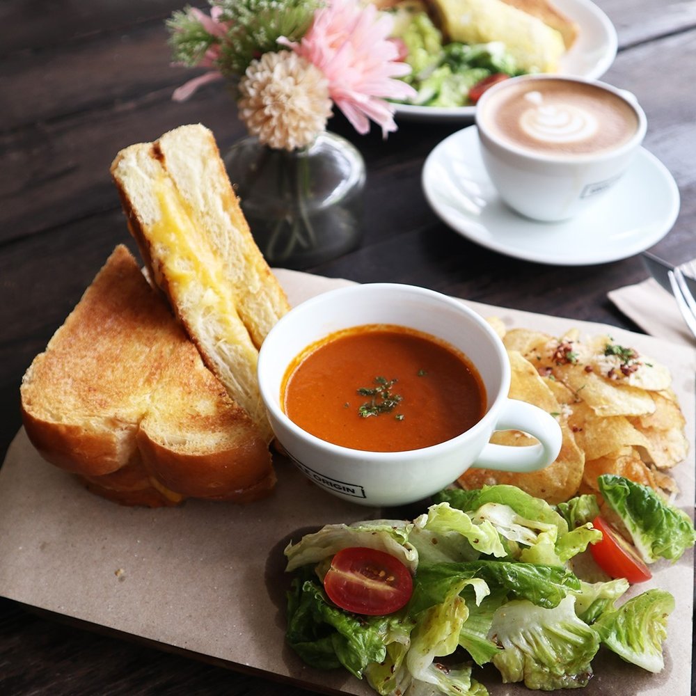 plate of grilled cheese with tomato soup and coffee on table