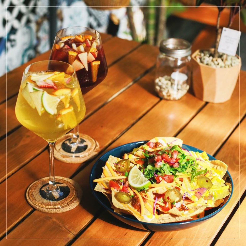 white and red sangria glasses and plate of nachos