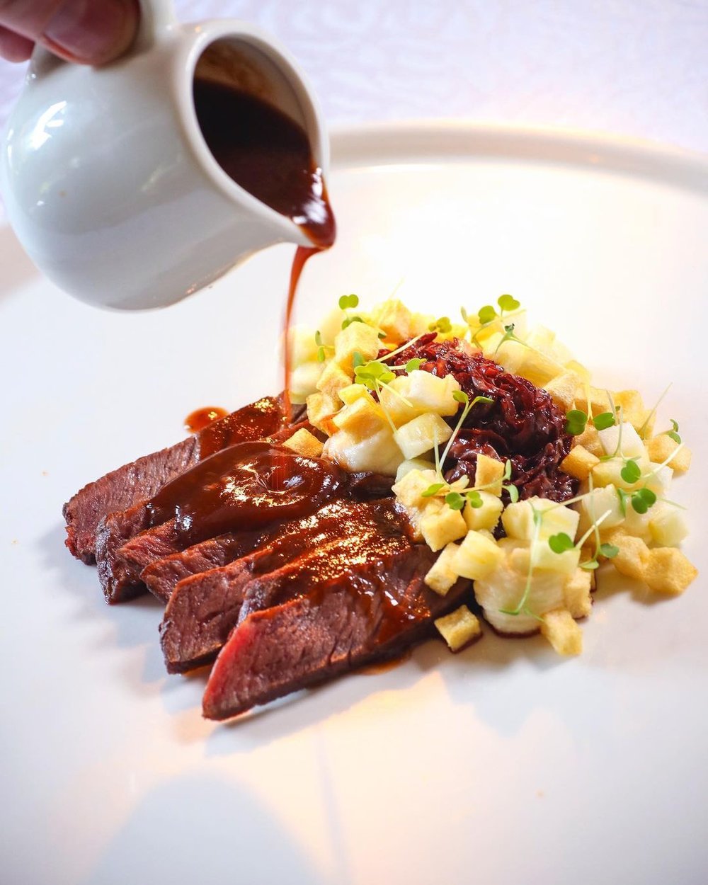 steak topped in garnish and gravy