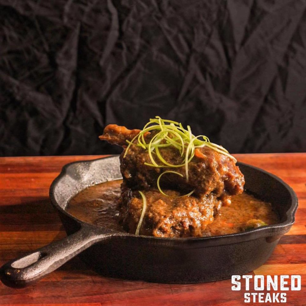 chicken fillet smothered with gravy on a black iron skillet