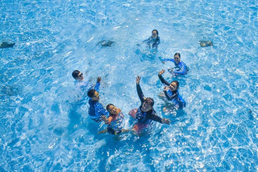 top view of people smiling inside swimming pool