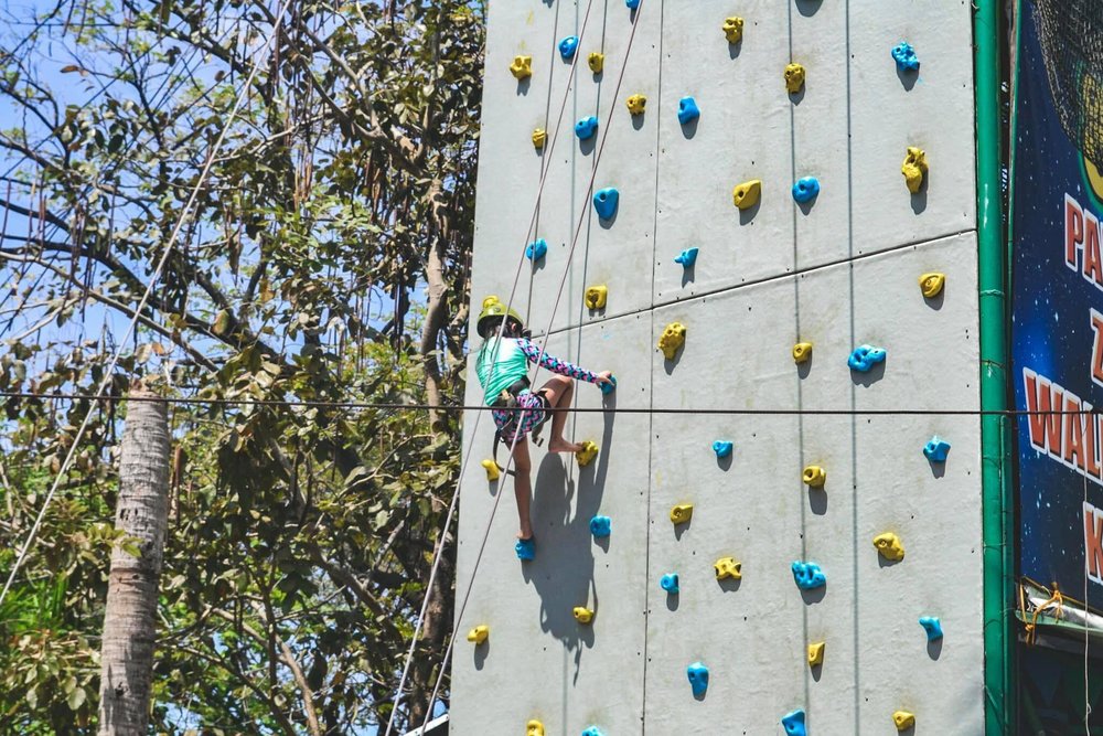 girl climbing a wall with harness