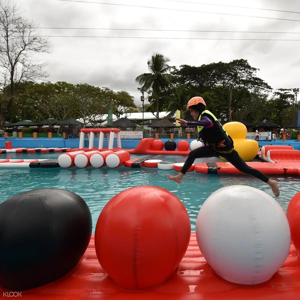 man jumping on inflatable ball course