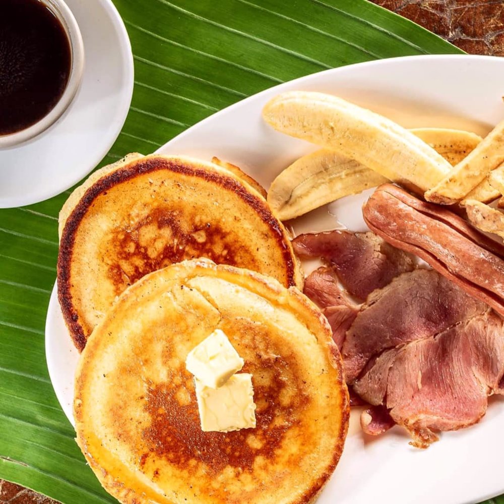 plate of pancakes, ham, sausage and banana