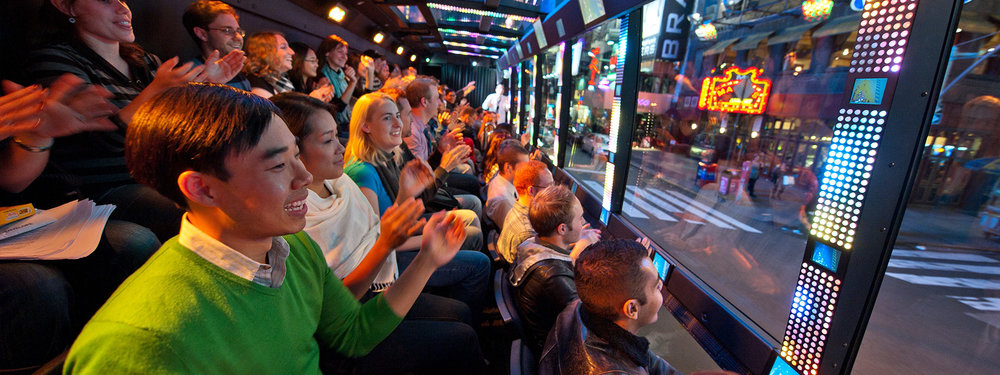 passengers enjoying the view from inside The Ride NYC Tour Bus