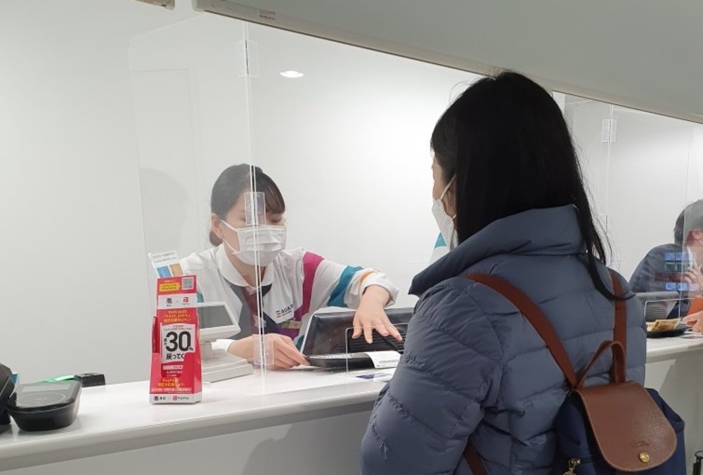 マクセルアクアパーク品川のチケット窓口でチケットを交換する女性