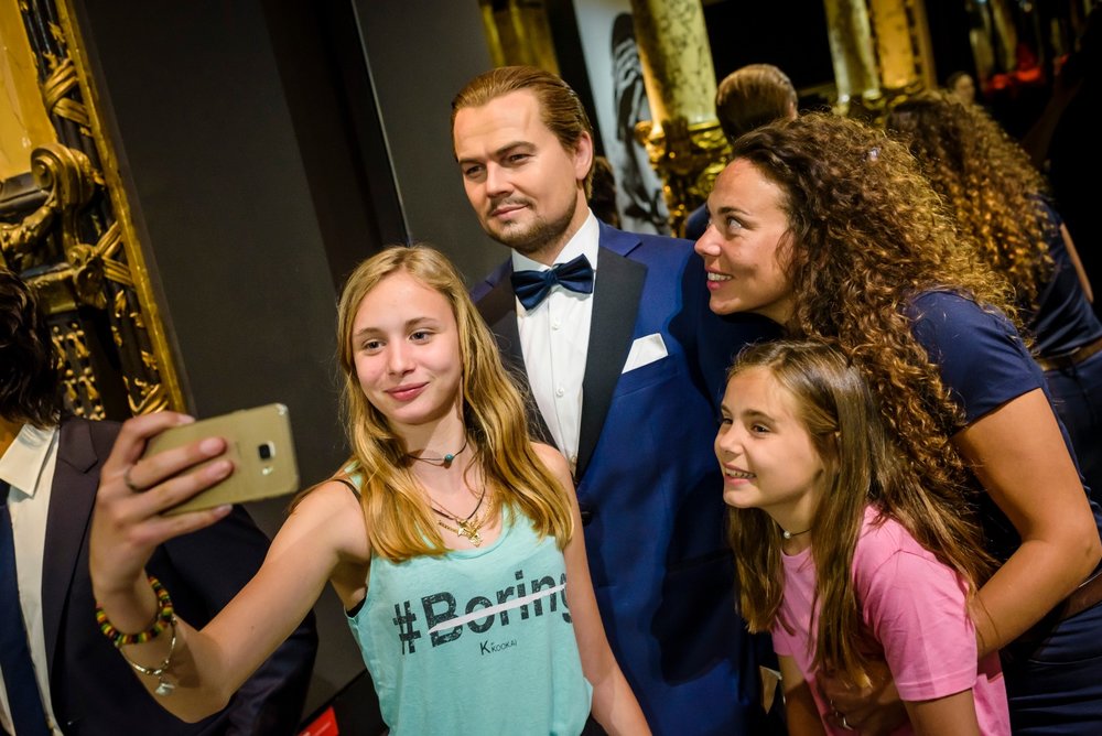 Tourists taking a selfie with Leonardo DiCaprio's wax figure