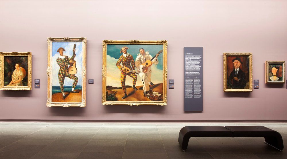 several paintings on display inside Musee de l"Orangerie