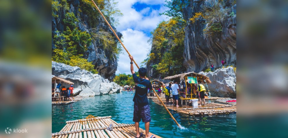 man rowing a bamboo raft