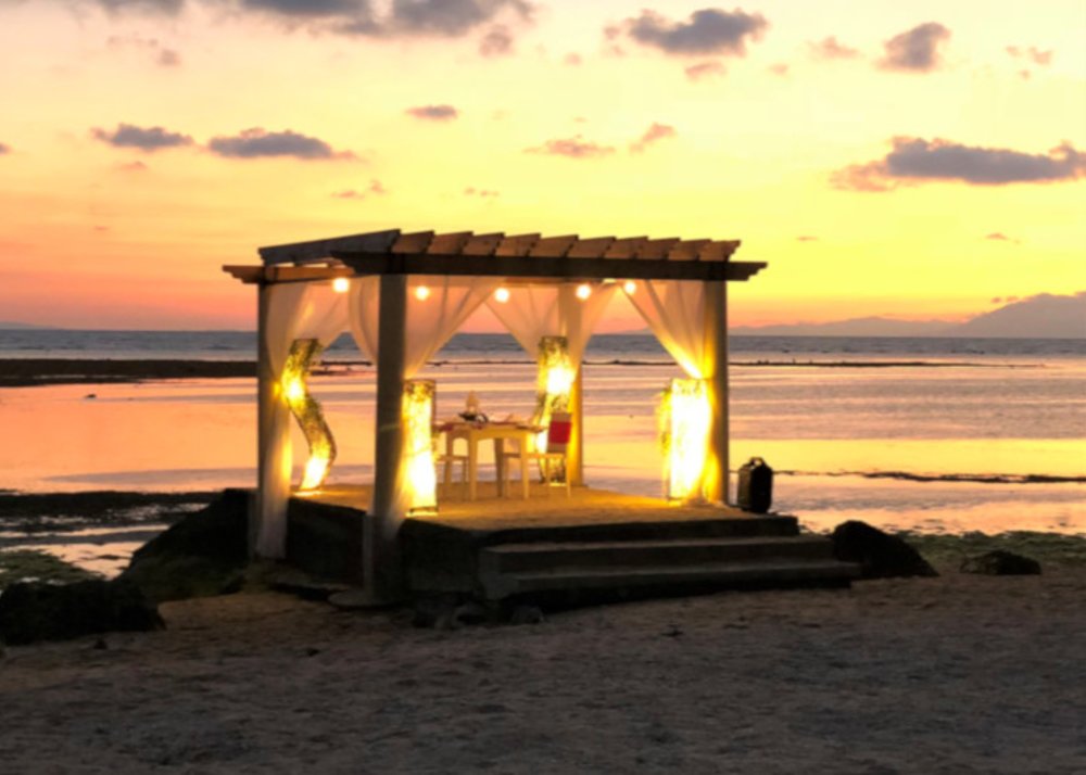 romantic sunset dining setup by the beach