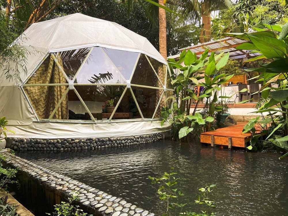 white dome tent next to pond