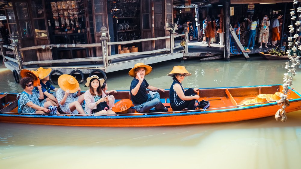 Tourists on a boat at a floating market in Thailand