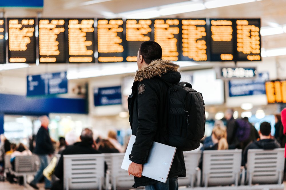 a person looking at the flight board in an airport