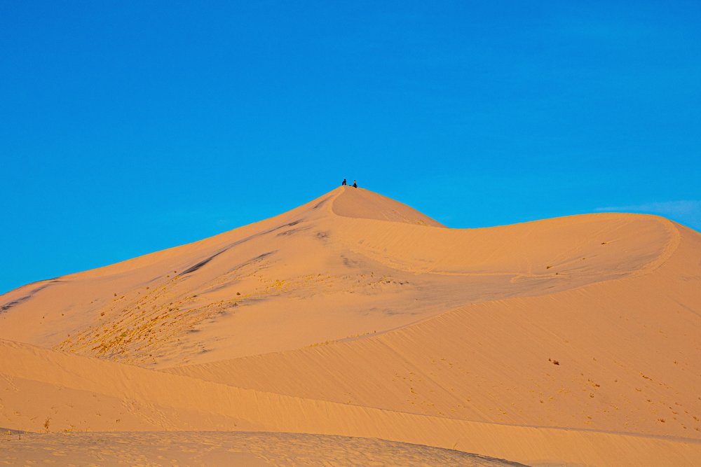 two people on sand dunes in mojave desert
