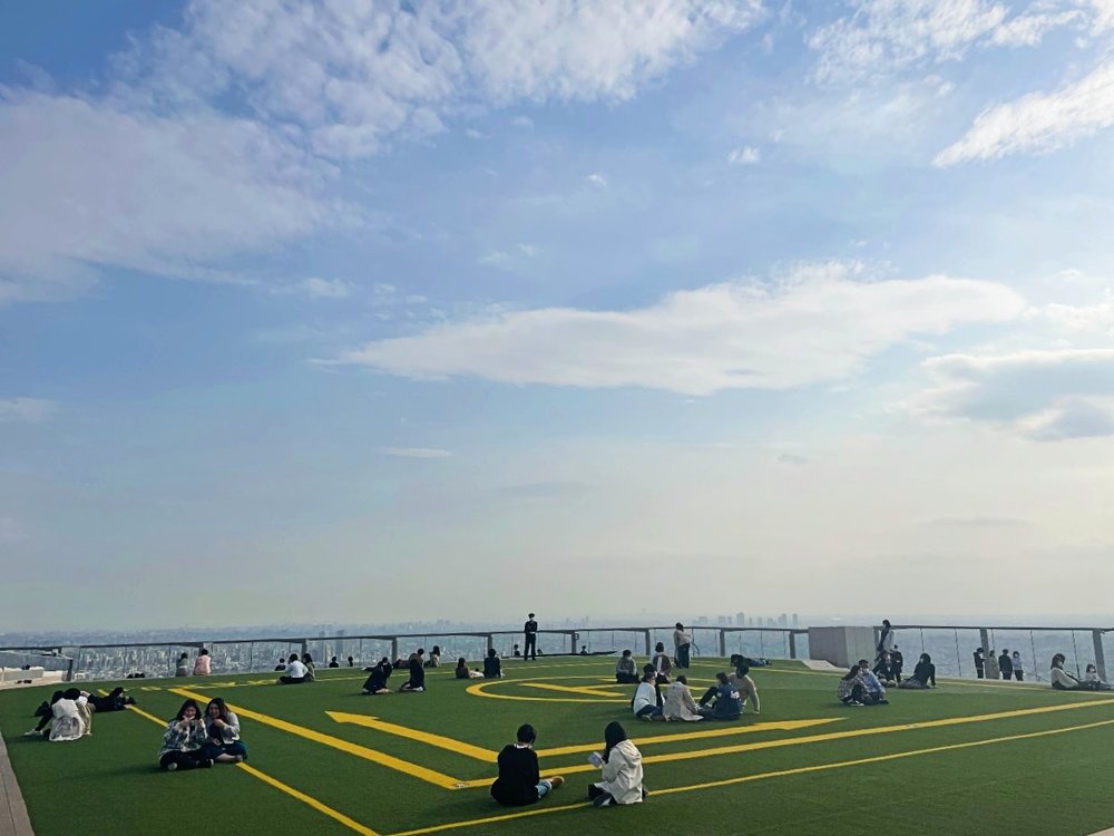 SHIBUYA SKY SKY STAGEの芝生に座る人々