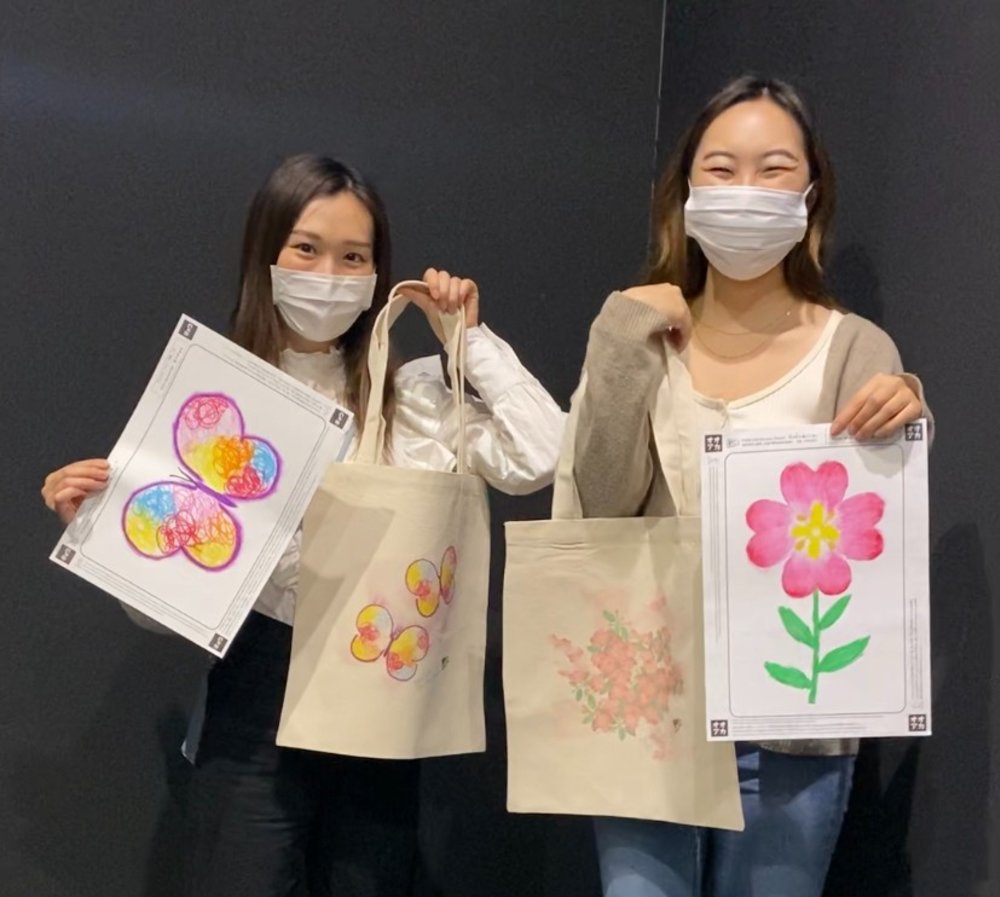 チームラボボーダレス お絵かきファクトリーで完成したトートバッグを持つふたりの女性