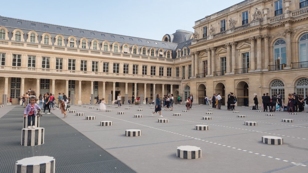 people playing on the black and white columns of the jardin du palais royal in paris france