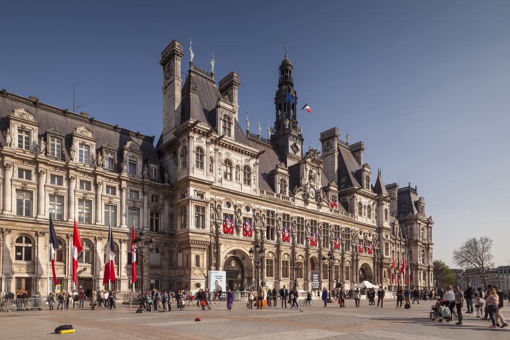 a crowd gathering in front of the hotel de ville in paris france