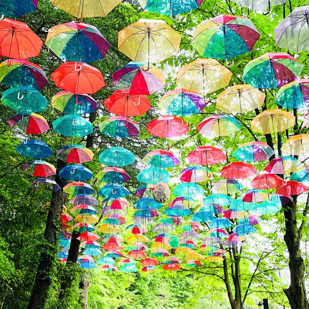 ムーミンバレーパーク アンブレラスカイ レインボーの傘の中にいるトゥーティッキ2022 