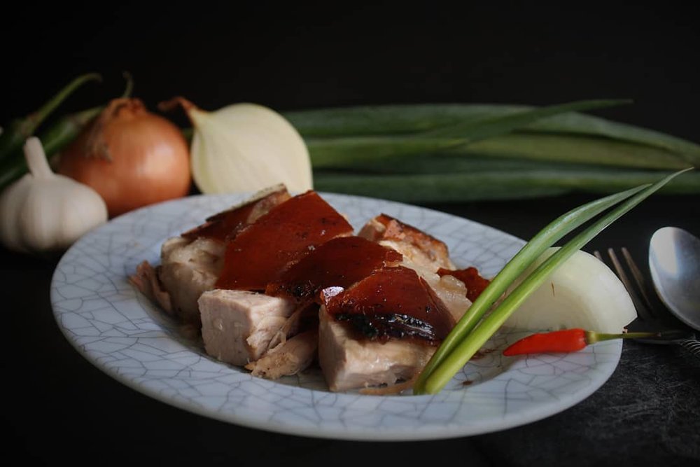 Chopped lechon in plate with vegetables