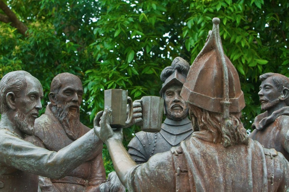 Statue of five men holding their glass in the air