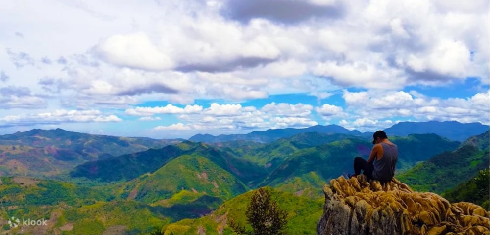 Man sitting in the rock formation with mountain view
