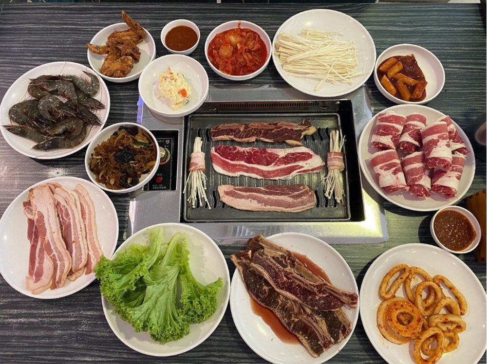 Set of meat, lettuces and side dishes in the table