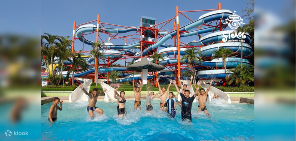 group of friends in pool with a giant slide background