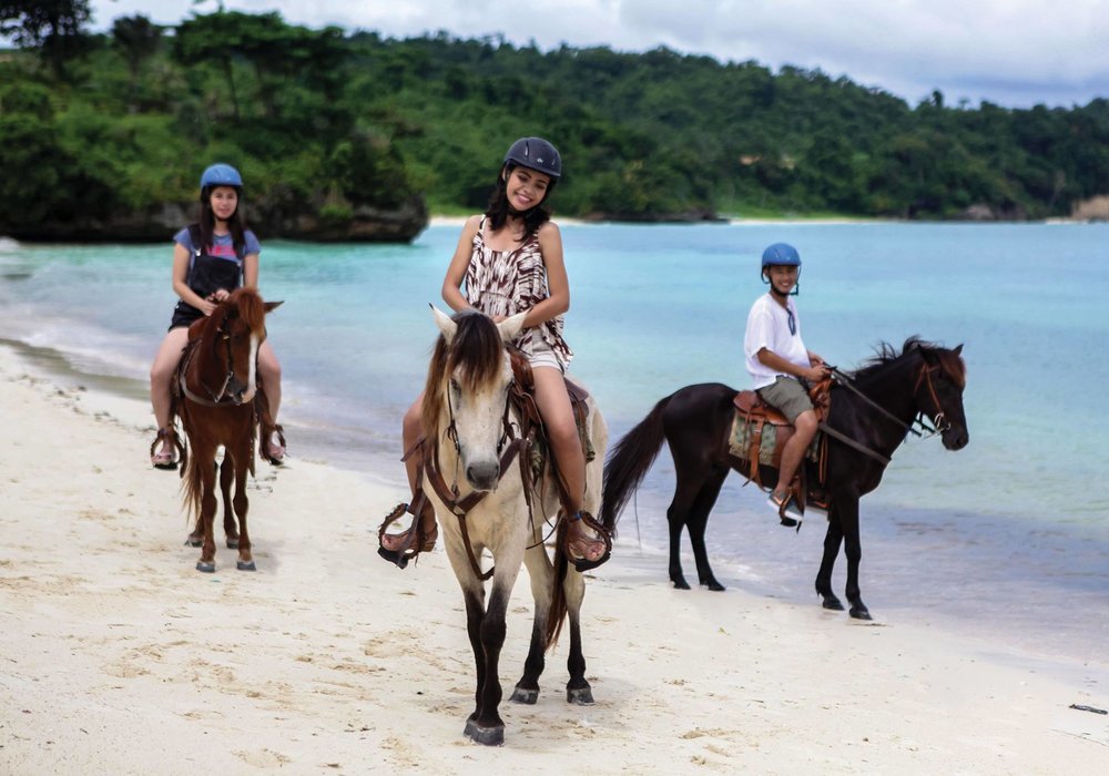 group of people riding horse at the beach