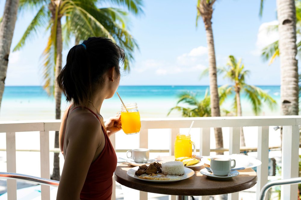 A young girl is having breakfast at a beautiful beach in Boracay Philippines