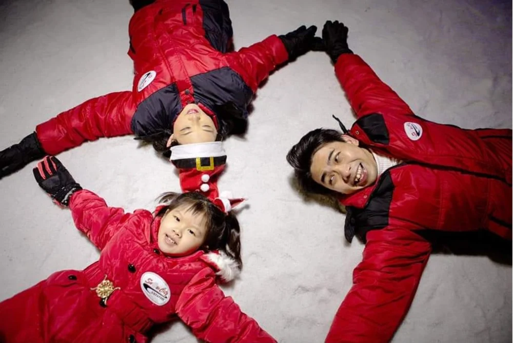 Family lying down and having fun in snow