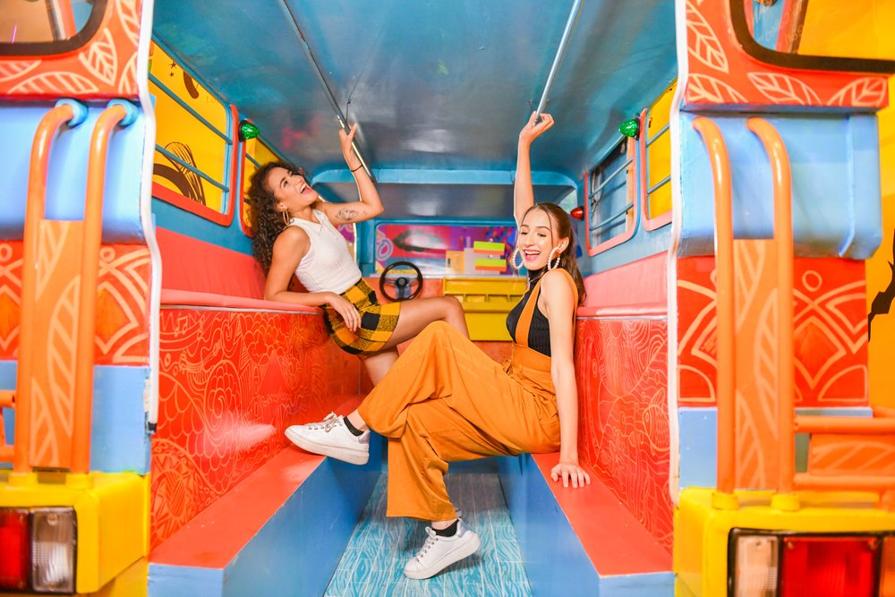 two girls riding in a colorful jeep