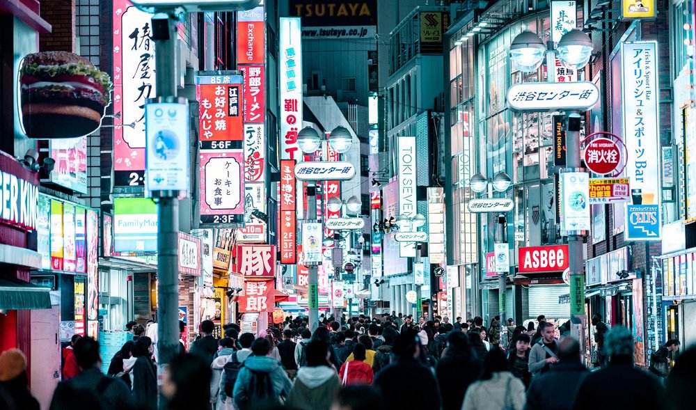 a street in Tokyo at night filled with many people